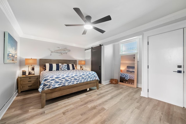 bedroom featuring ceiling fan, ornamental molding, a barn door, and light wood-type flooring