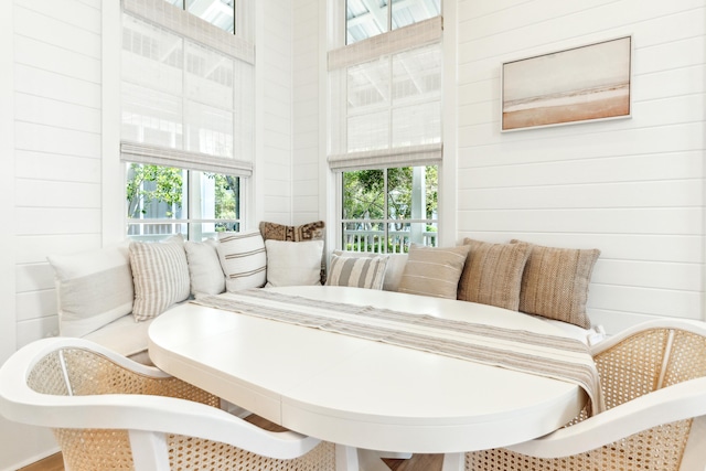 dining area with a high ceiling and wood walls