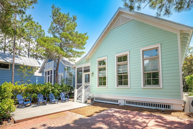 back of property with a sunroom and a patio area