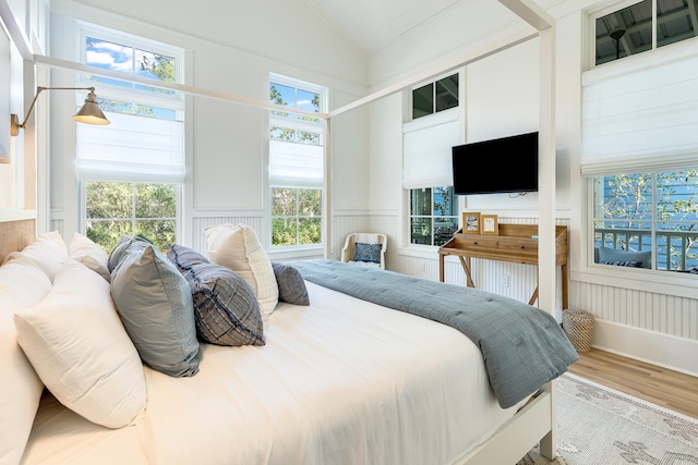 bedroom with multiple windows, light hardwood / wood-style flooring, and high vaulted ceiling