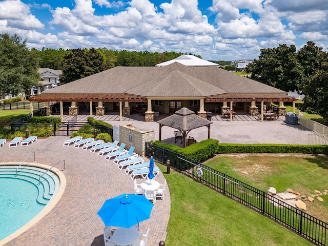 community pool featuring a patio area, a gazebo, fence, and a yard