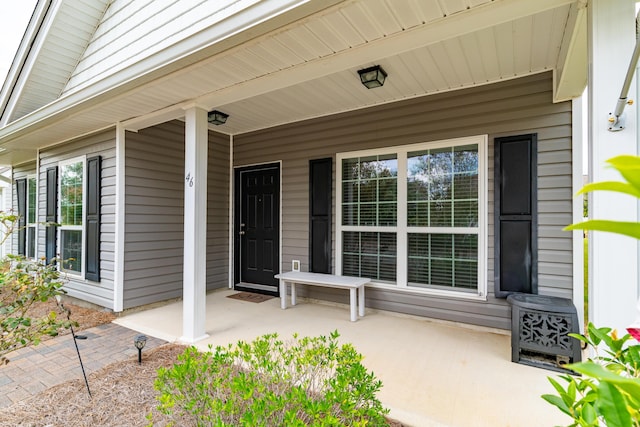 view of exterior entry featuring covered porch