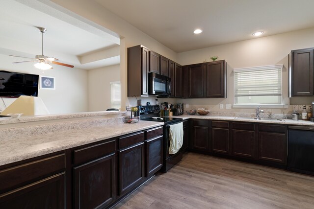 kitchen featuring ceiling fan, plenty of natural light, light hardwood / wood-style floors, sink, and black appliances