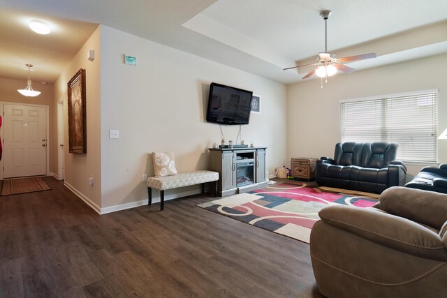 living room with dark hardwood / wood-style flooring and ceiling fan