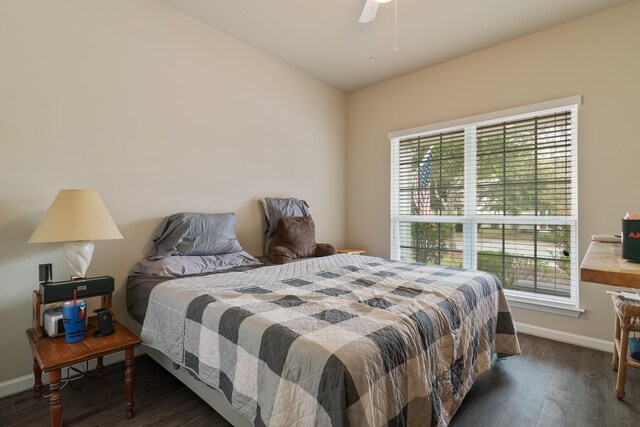 bedroom featuring ceiling fan, dark wood-type flooring, and multiple windows