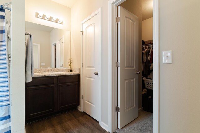 bathroom featuring hardwood / wood-style floors, a shower with shower curtain, and vanity