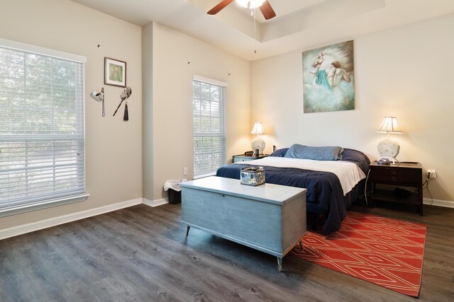 bedroom with dark hardwood / wood-style flooring and ceiling fan