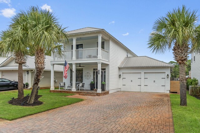 view of front of house featuring a garage, a porch, a front yard, a balcony, and ceiling fan