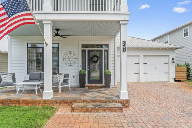 entrance to property with a balcony, ceiling fan, and a garage