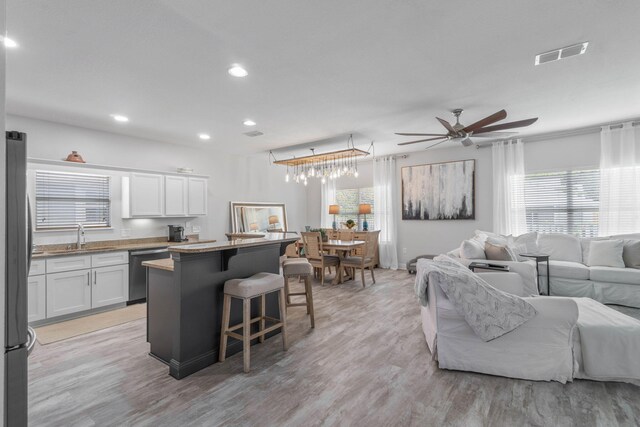 kitchen with white cabinetry, light hardwood / wood-style floors, stainless steel appliances, and a healthy amount of sunlight