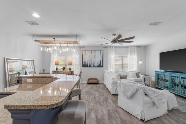 living room featuring ceiling fan and light wood-type flooring