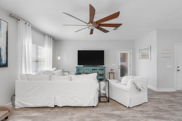 living room featuring light wood-type flooring and ceiling fan