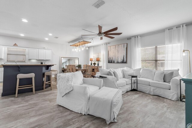 living room with light hardwood / wood-style flooring and ceiling fan