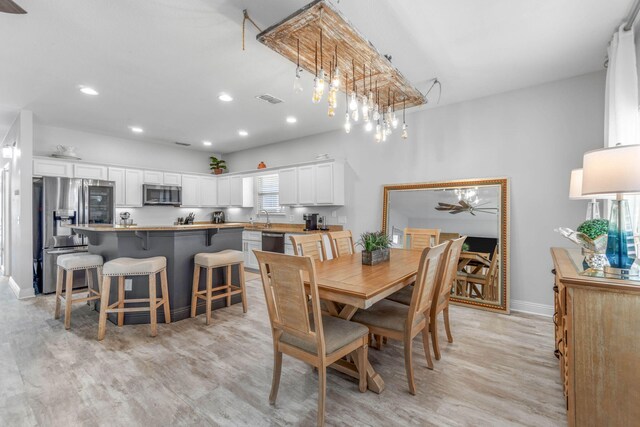 dining area with sink and light wood-type flooring