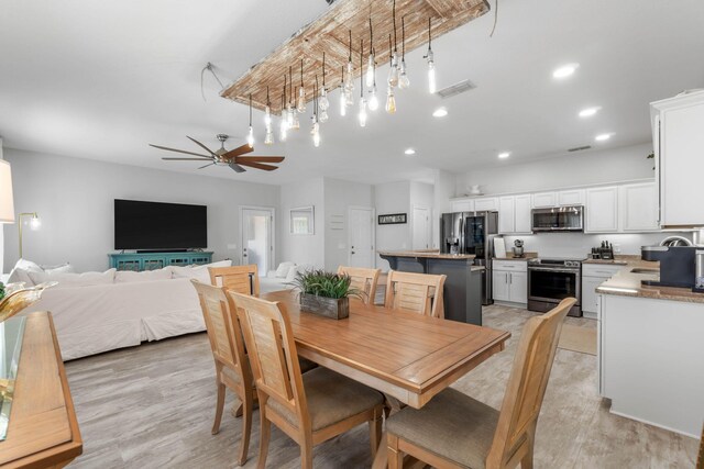 dining space featuring ceiling fan, sink, and light hardwood / wood-style floors