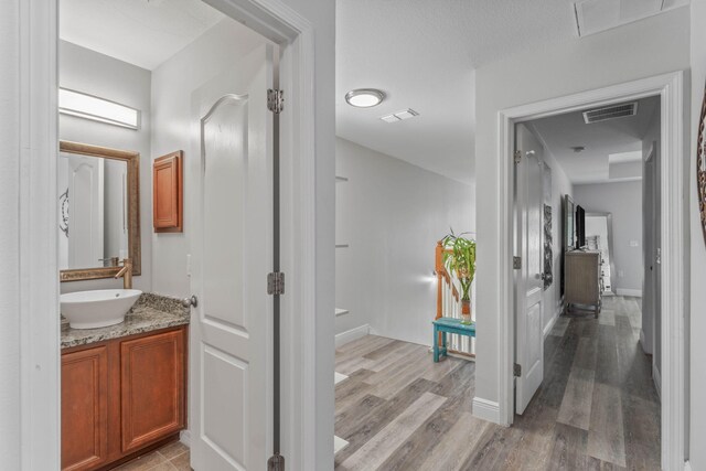 hallway featuring sink and light wood-type flooring