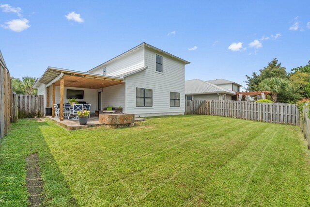 rear view of property featuring a patio and a yard