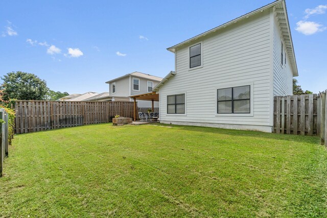 rear view of property featuring a yard and a patio