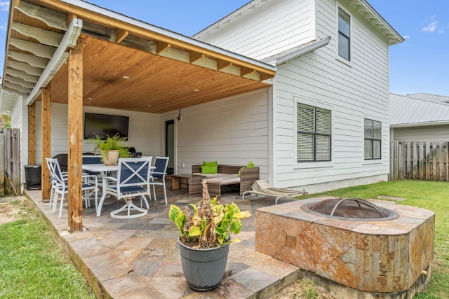 rear view of house featuring a patio and an outdoor living space with a fire pit