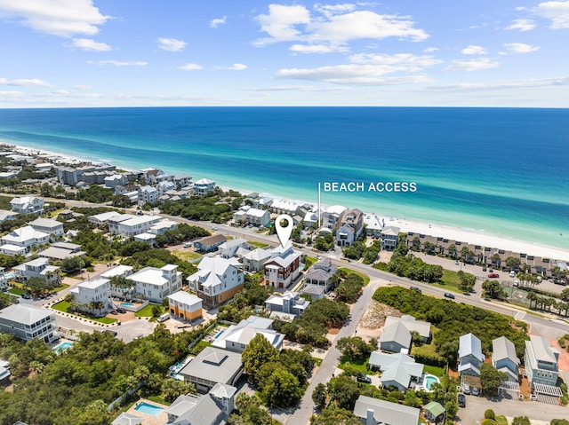 drone / aerial view featuring a water view, a residential view, and a view of the beach