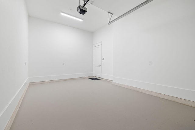 garage with baseboards and a garage door opener