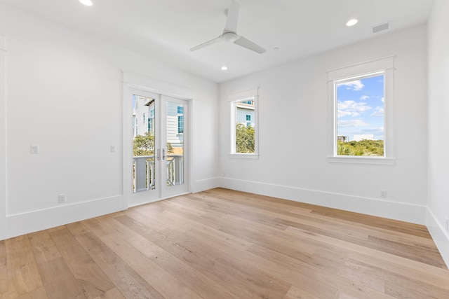 unfurnished room featuring light wood finished floors, visible vents, and a wealth of natural light