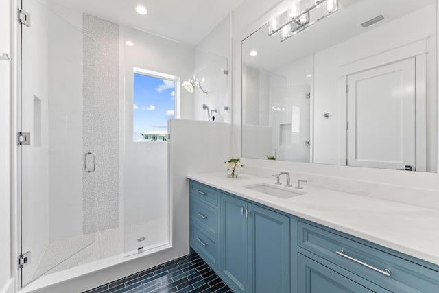 bathroom featuring tile patterned floors, a shower with door, and vanity