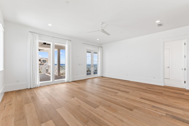 unfurnished room featuring light wood-style flooring, visible vents, ceiling fan, and baseboards