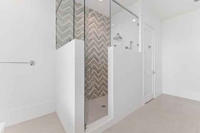 bathroom featuring a tile shower and tile patterned flooring