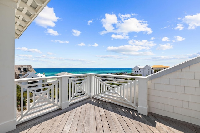 wooden deck featuring a water view and a beach view