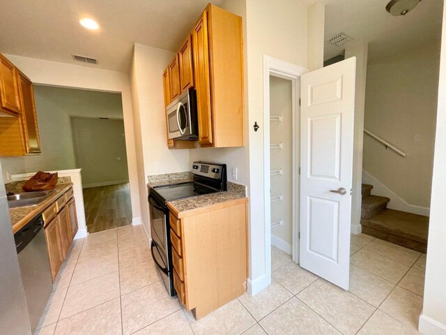 kitchen featuring appliances with stainless steel finishes, light tile patterned floors, and sink