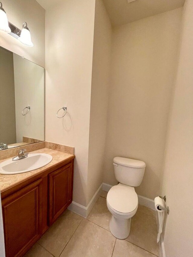 bathroom featuring vanity, tile patterned flooring, and toilet