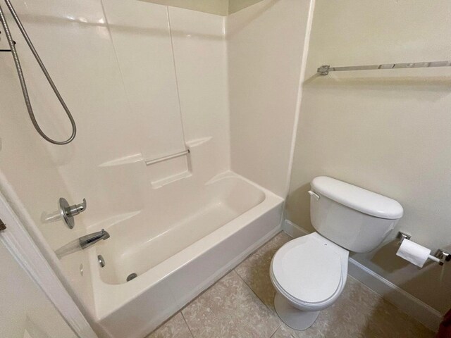 bathroom featuring tile patterned floors, toilet, and shower / bathtub combination