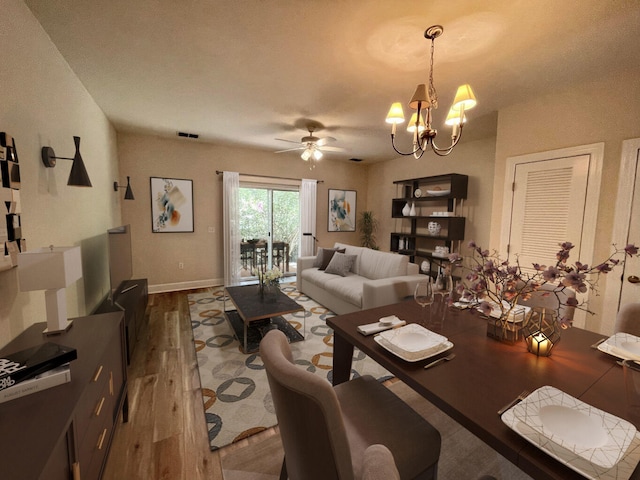 interior space featuring ceiling fan with notable chandelier and wood-type flooring