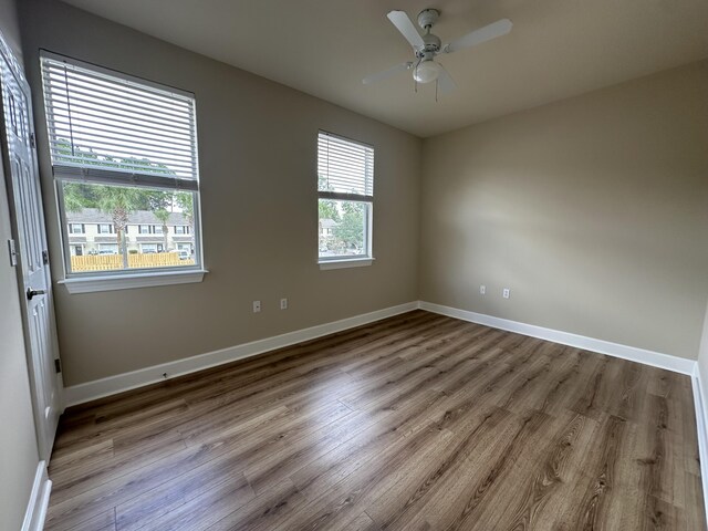 unfurnished room featuring a healthy amount of sunlight, light hardwood / wood-style floors, and ceiling fan