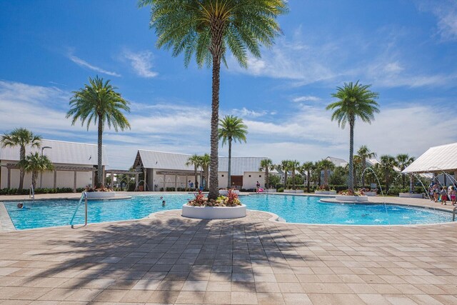 view of pool featuring pool water feature and a patio