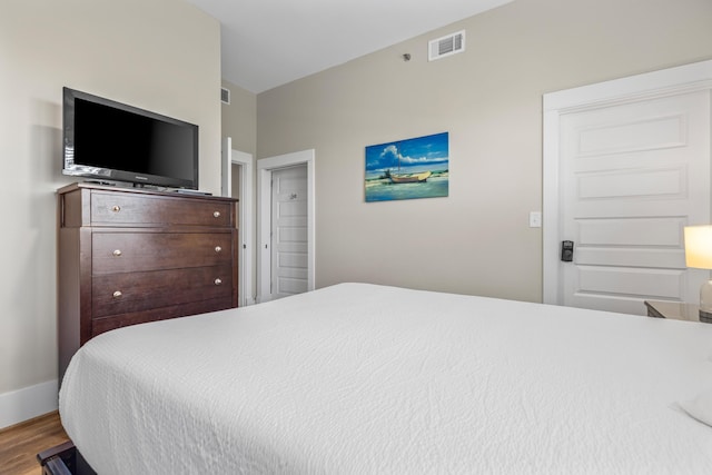 bedroom featuring baseboards, visible vents, and wood finished floors