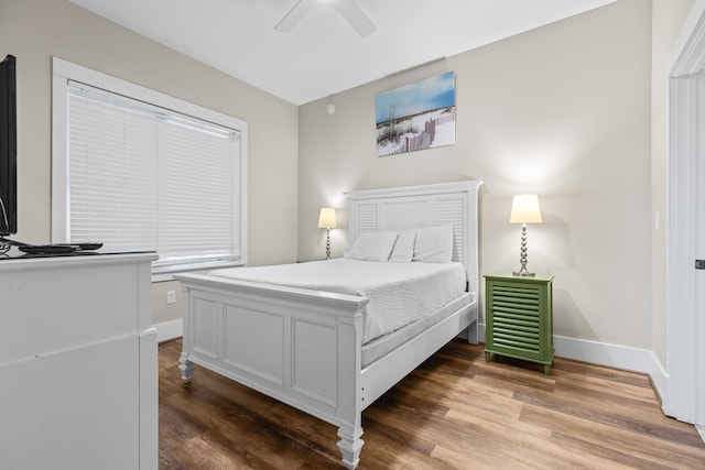 bedroom with baseboards, ceiling fan, and wood finished floors
