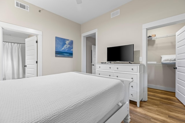 bedroom with a closet, ceiling fan, visible vents, and wood finished floors