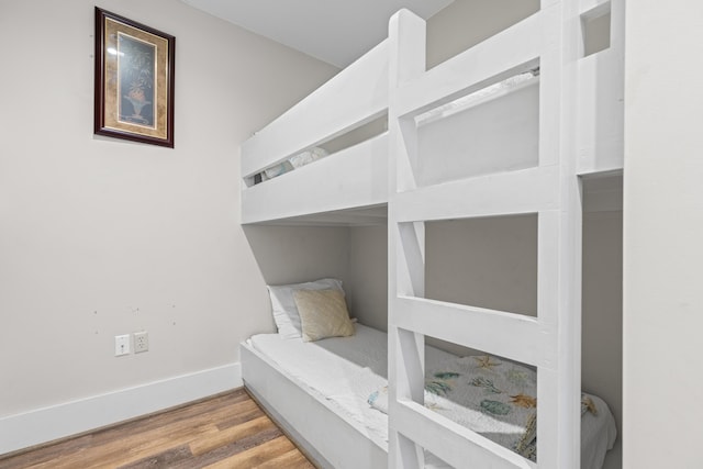 bedroom featuring baseboards and wood finished floors