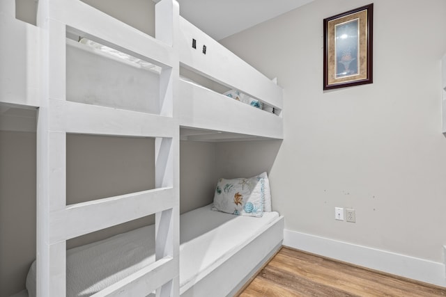 bedroom with baseboards and wood finished floors