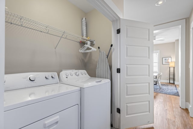 laundry room featuring baseboards, washer and dryer, light wood-style flooring, and laundry area