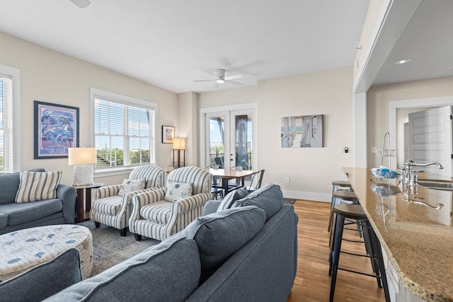 living room featuring baseboards, ceiling fan, wood finished floors, and french doors