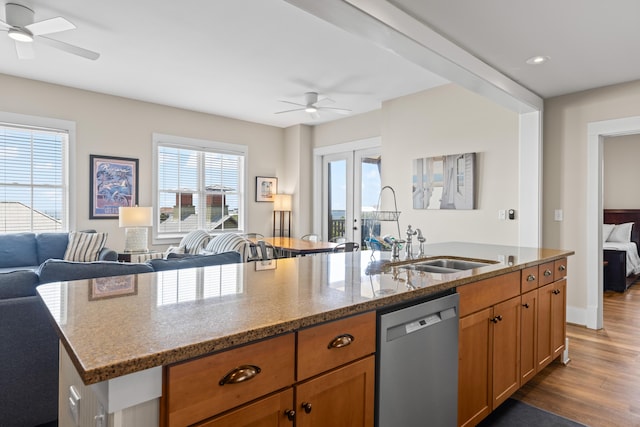 kitchen featuring ceiling fan, stone counters, stainless steel dishwasher, and open floor plan