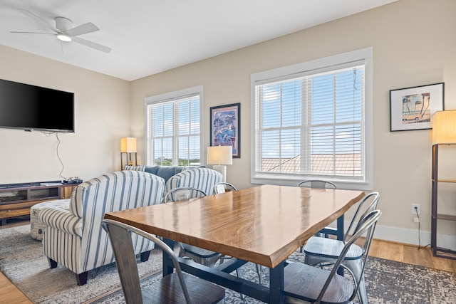 dining area with baseboards, light wood-style flooring, and a ceiling fan