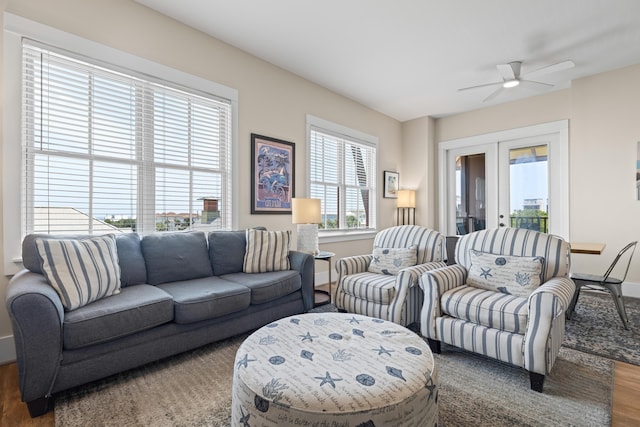 living area with baseboards, wood finished floors, french doors, and a ceiling fan