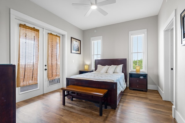 bedroom with baseboards, access to exterior, wood finished floors, and french doors