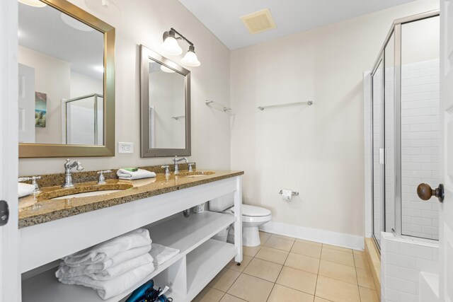 bathroom featuring an enclosed shower, tile patterned floors, dual bowl vanity, and toilet