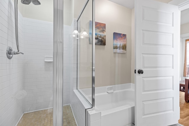 bathroom featuring plus walk in shower and hardwood / wood-style flooring