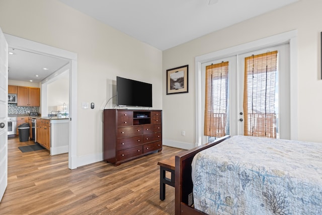 bedroom featuring baseboards, wood finished floors, and access to outside